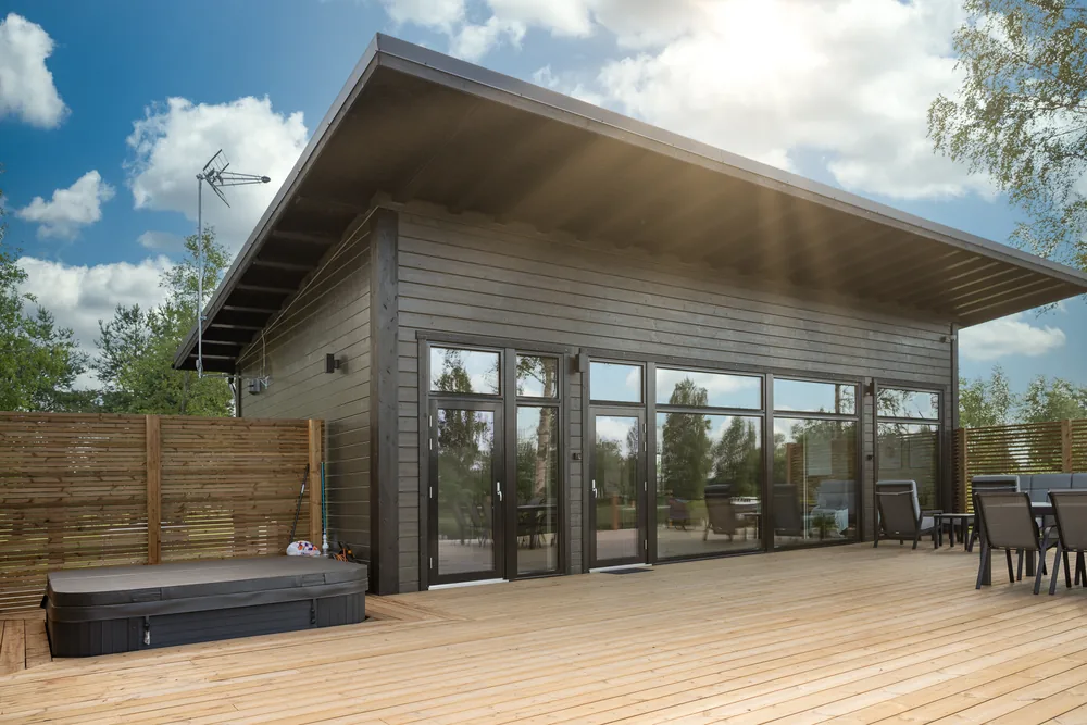 Villa Suisto ulkoa kesäpäivänä, terassi ja poreamme